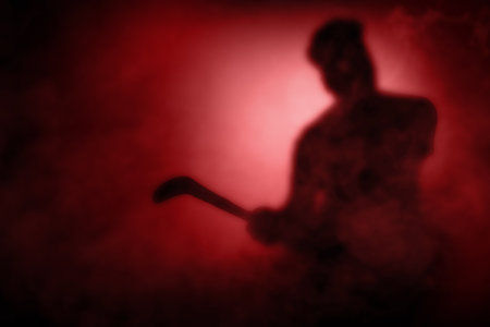 Silhouette of a scary zombie holding sickle with dramatic backgroundの写真素材