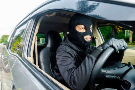 Car thief man runaway with a stolen car on the streetの写真素材