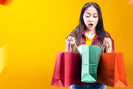 Asian woman carrying shopping bags with colored background