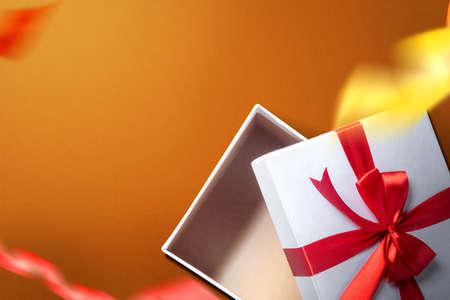 Opened a white gift box with a red ribbon with a colored background. Boxing Dayの写真素材