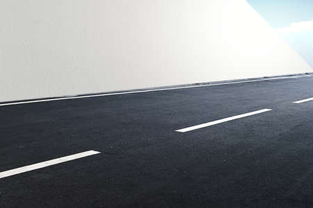 Close up view of a street with white wall and blue sky backgroundの写真素材