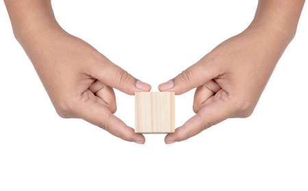 Hand holding wooden block toy isolated over white backgroundの写真素材