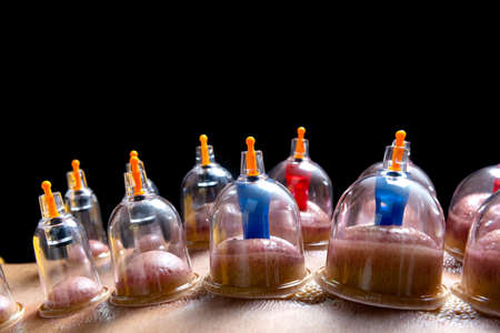 Man with cupping treatment on the back with black background