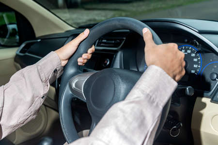 Man with his hands on the steering wheel driving a carの写真素材