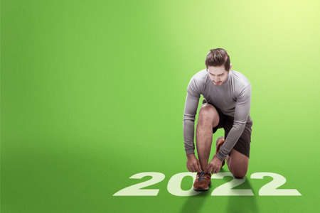 Asian runner man preparing to run in 2022. Happy New Year 2022