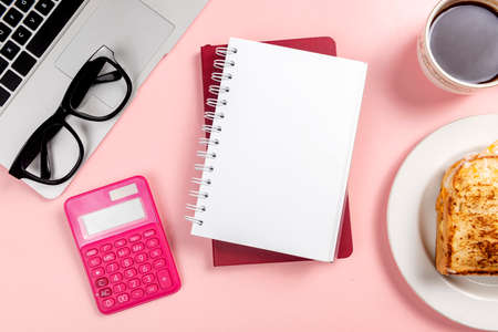 Laptop and note book with breakfast and coffee with colored backgroundの写真素材