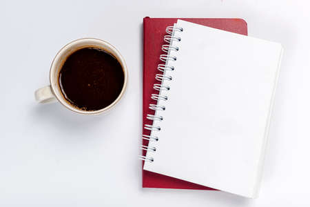 Note book with coffee on white deskの写真素材