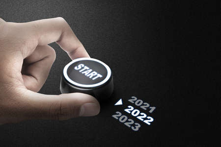 Human hand turning knob to start 2022. Happy New Year 2022