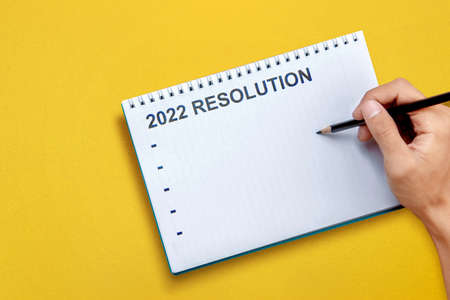 Human hand writes a list for 2022 resolution on the note book. Resolution of 2022. Happy New Year 2022の写真素材
