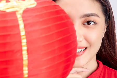 Asian Chinese woman in a cheongsam dress holding lantern isolated over white backgroundの写真素材