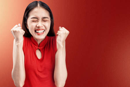 Asian Chinese woman in a cheongsam dress with happy expression celebrates Chinese New Year. Happy Chinese New Yearの写真素材