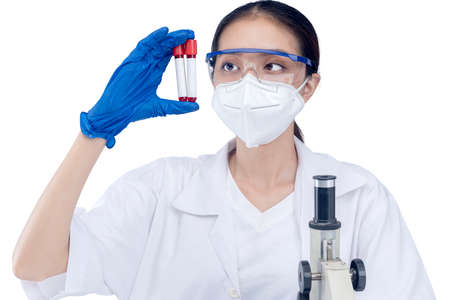 Asian researcher woman with face mask and glasses holding medical tube isolated over white...