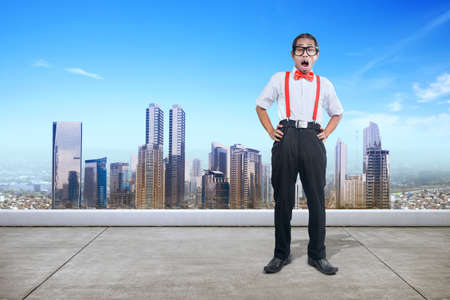 Asian nerd with ugly face standing with cityscapes background