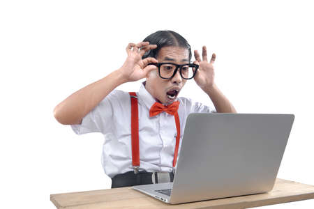 Asian nerd with an ugly face using laptop isolated over white background