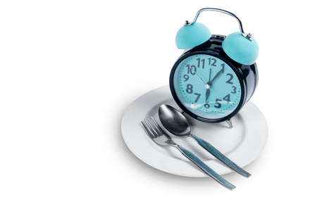 Clock with spoon and fork on the plate. Fasting conceptの写真素材