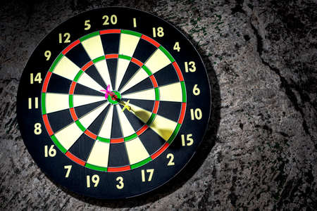 Dart arrow in the target center with dart arrow missed the target with black background