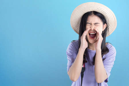 Asian woman with hat and camera yelling something with colored backgroundの写真素材