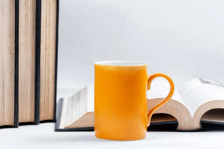 Closeup view of the opened book with a mug on the deskの写真素材