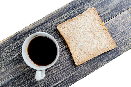 Sliced bread and a cup of coffee on the board isolated over white backgroundの写真素材