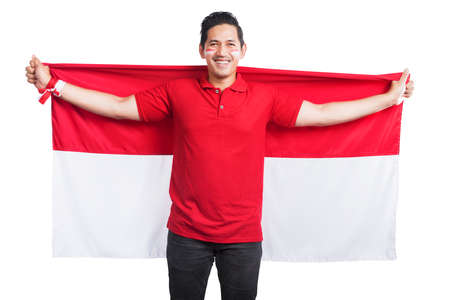 Indonesian men celebrate Indonesian independence day on 17 August by holding the Indonesian flag isolated over white backgroundの写真素材