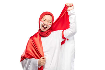 Indonesian women celebrate Indonesian independence day on 17 August by holding the Indonesian flag isolated over white backgroundの写真素材