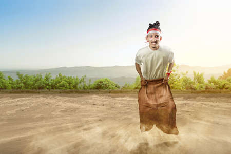 Indonesian men celebrate Indonesian independence day on 17 August with a sack race. Indonesian...