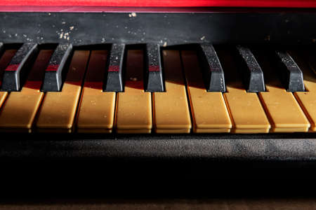 Closeup view of an electronic piano keyboard with dark backgroundの写真素材