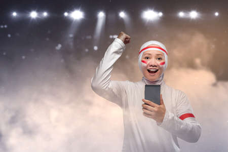 Indonesian women celebrate Indonesian independence day on 17 August while holding mobile phones. Indonesian independence dayの写真素材