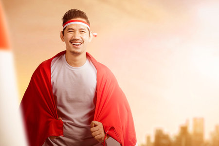 Indonesian men celebrate Indonesian independence day on 17 August by holding the Indonesian flag. Indonesian independence dayの写真素材