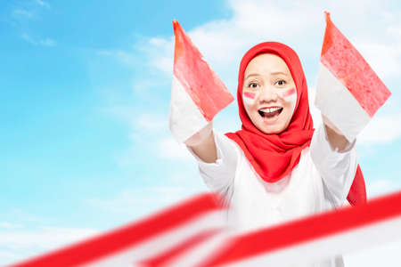 Indonesian women celebrate Indonesian independence day on 17 August by holding the Indonesian flag. Indonesian independence dayの写真素材