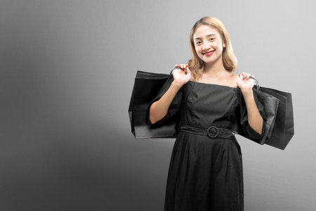 Asian woman carrying a shopping bag with a colored background. Black Friday concept