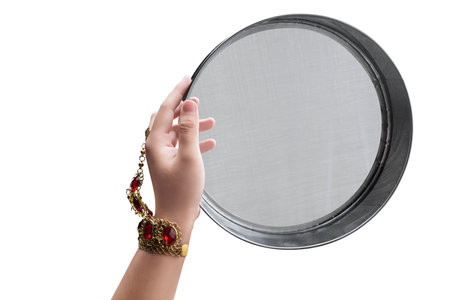 Woman hand holding Karwa Chauth strainer for the Karwa Chauth celebration are isolated over white...