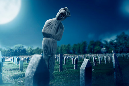 Pocong is covered with a white linen shroud standing in the cemetery. Halloween conceptの写真素材