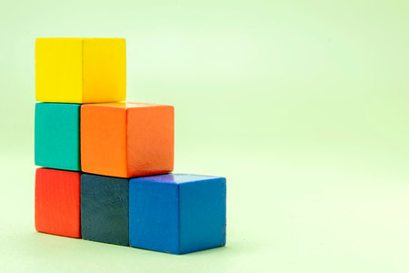Stairs of colorful wooden block toys on a colored backgroundの写真素材