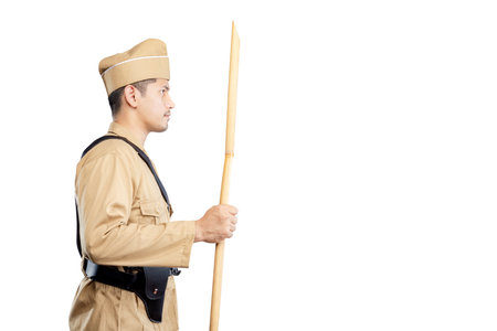 Indonesian freedom fighter standing while holding sharpened bamboo stick isolated over white...