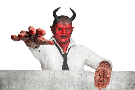 Devilman standing behind the wall isolated over white background. Halloween conceptの写真素材