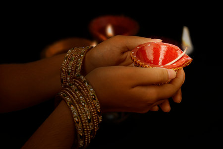 Woman hand holding Diya oil lamps for the Diwali festival. Hindu festival of lights celebration