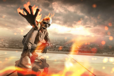 Man with a skull head costume is on fire with a dramatic scene background. Halloween concept