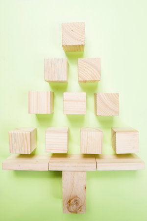 Wooden cubes shaped a Christmas tree on a colored background. Christmas decoration