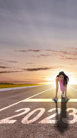 Asian runner woman ready to run on the 2023 line. Happy New Year 2023