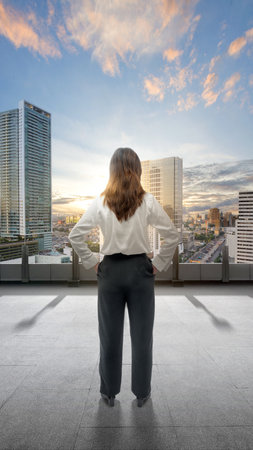 Rear view of Asian businesswoman standing in cityscape backgroundの写真素材