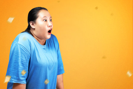Asian fat overweight woman with a shocked expression and with colored background