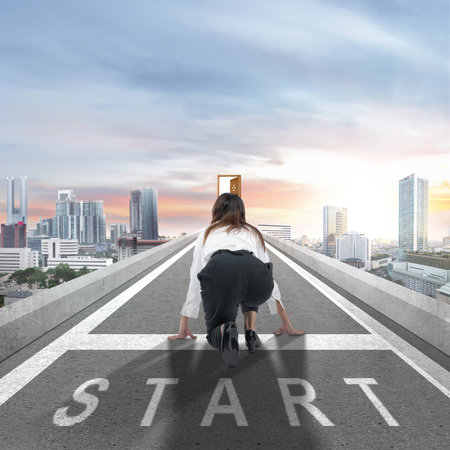 Rear view of Asian businesswoman in start position ready to run on the streetの写真素材