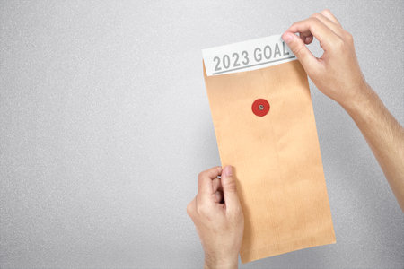 Human hands are opening envelopes with the 2023 goal. Goals of 2023. Happy New Year 2023の写真素材