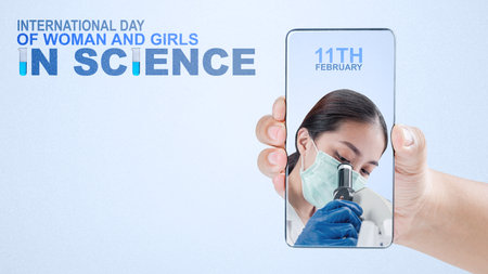 Human hands holding mobile phones with a screen of Asian scientists using microscopes with a colored...