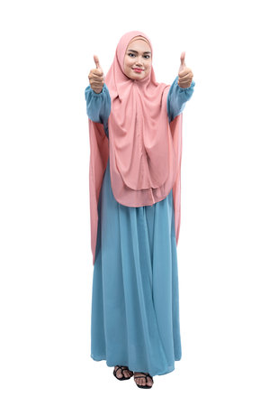 Asian Muslim woman in veil showing thumb up sign isolated over white backgroundの写真素材