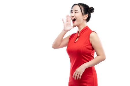 Asian Chinese woman in a cheongsam dress yelling something isolated over white backgroundの写真素材