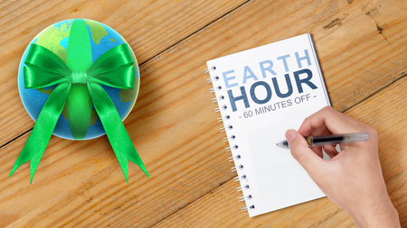 Human hand write something in a notebook. Earth Hour Conceptの写真素材