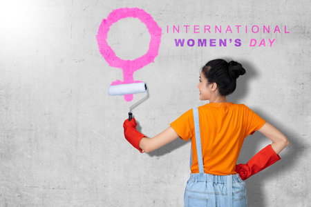 Asian woman holding roller paint brush with International Women's Day text. International Women Dayの写真素材