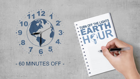 Humans hand write something in a notebook. Earth Hour Conceptの写真素材